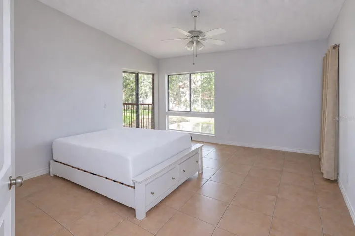 Bedroom 2 with pond view and slider access to balcony. One closet at right; a second one left of the entry door.
