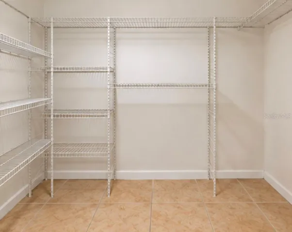 Spacious walk-in closet with added shelving.