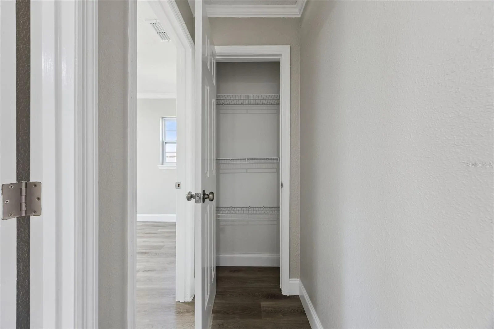 Hallway Linen Closet: Convenient central hallway storage closet equipped with built-in wire shelving