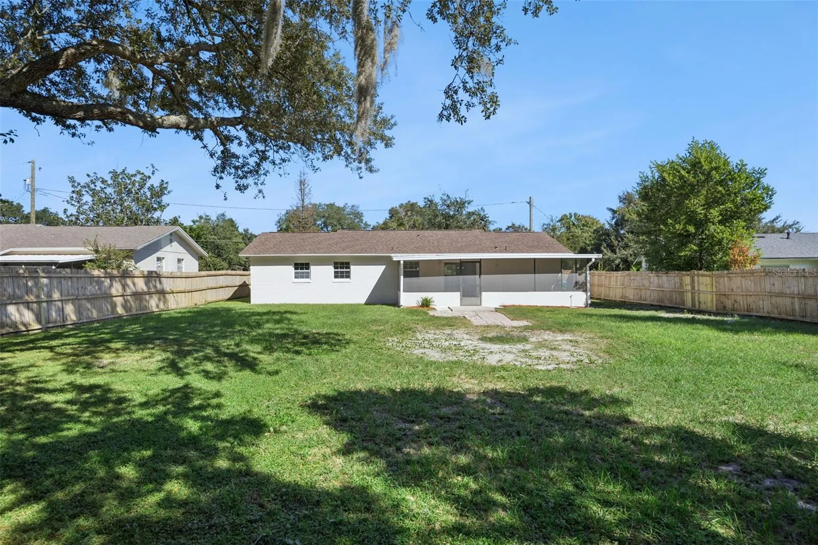 Expansive Backyard: Massive fully fenced backyard framed by majestic mature shade trees, offering ample room for outdoor recreation.
