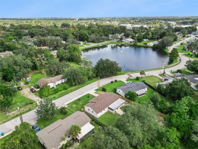 Aerial View Near Lake: High-angle aerial shot capturing the home's proximity to a scenic neighborhood lake with a central water fountain feature.