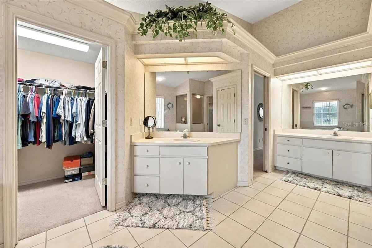 Primary bath with dual sinks, vanities and walk in closets