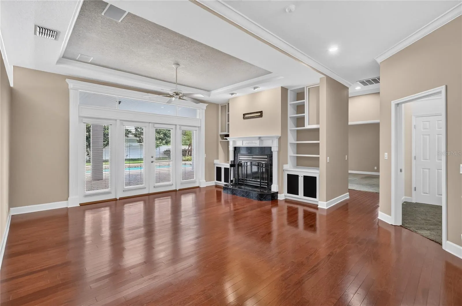 Family Room with Fireplace and Built In Shelving over looking the Pool