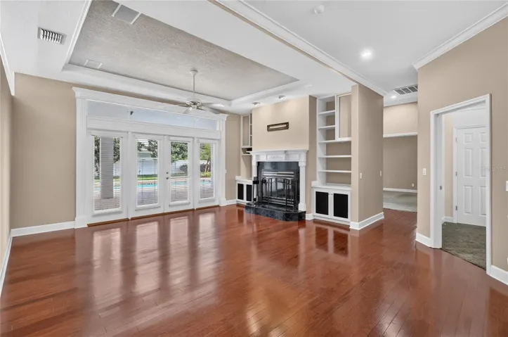 Family Room with Fireplace and Built In Shelving over looking the Pool