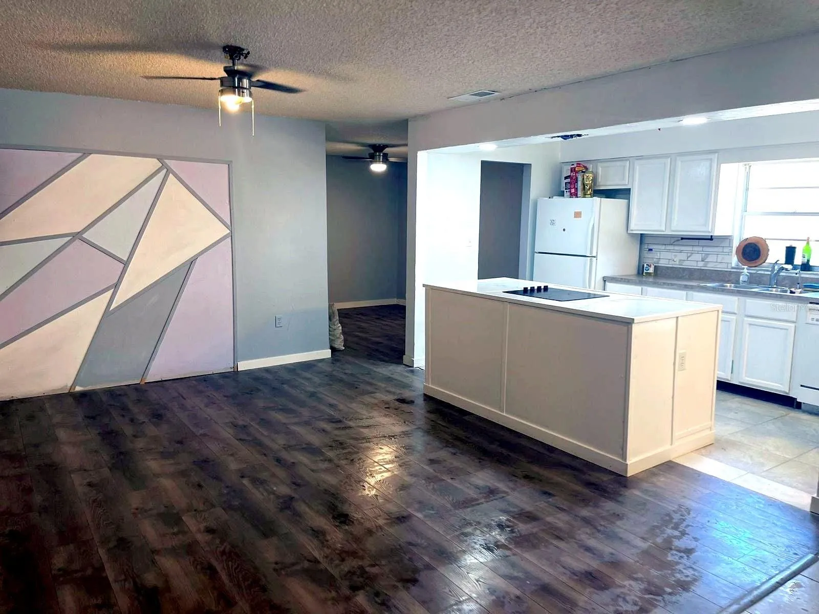 Open floor plan living room flowing into kitchen with island