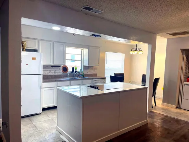 Kitchen with white cabinets, island and dining area