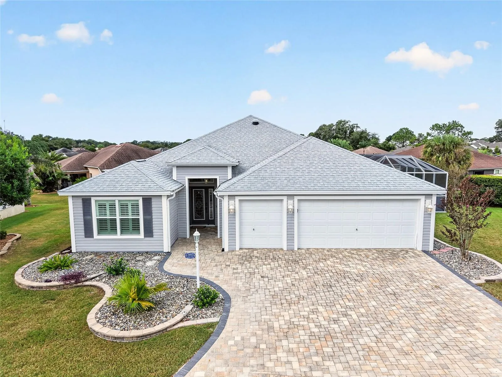 Beautifully tiered landscaping and a charming paver driveway welcome you home. A two-car garage plus golf cart garage adds everyday convenience.