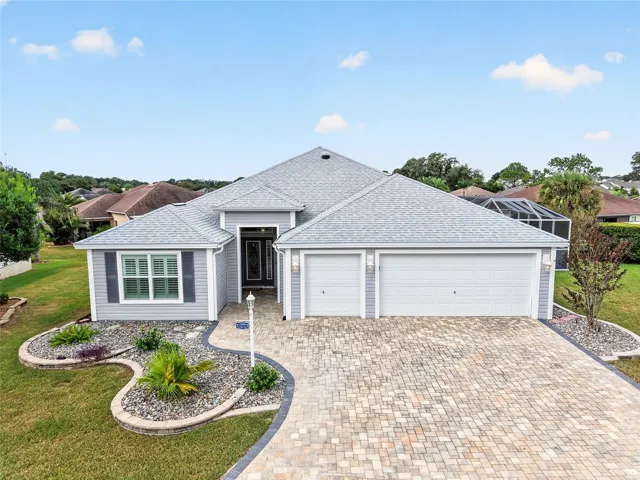 Beautifully tiered landscaping and a charming paver driveway welcome you home. A two-car garage plus golf cart garage adds everyday convenience.
