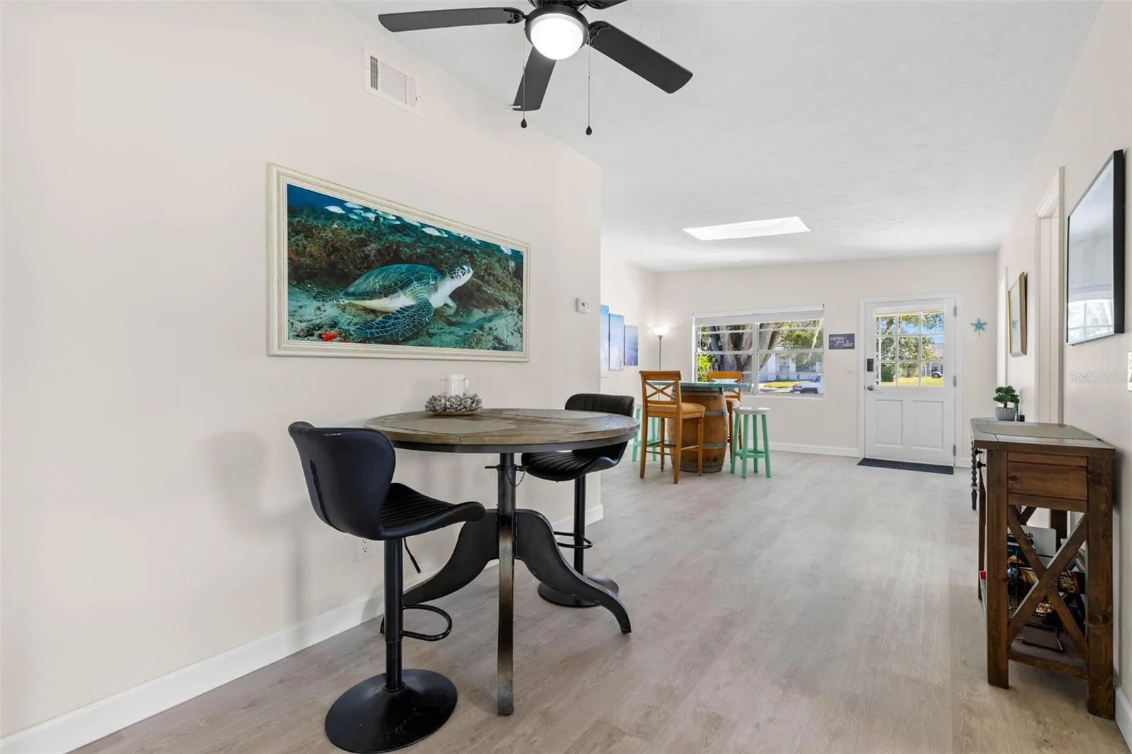 A flexible casual dining area features neutral tones, 2025 luxury vinyl plank flooring, and a ceiling fan, with an open layout that easily accommodates a breakfast table, work-from-home spot, or additional gathering space.