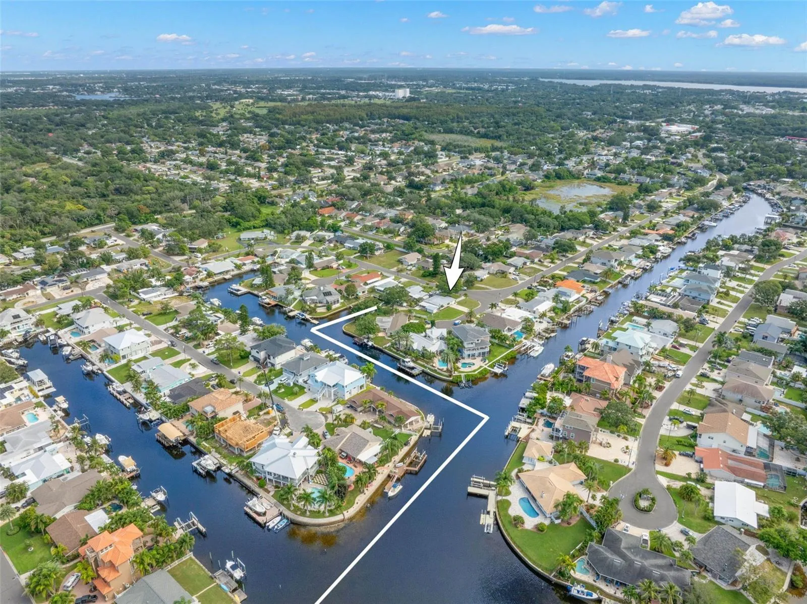 A dramatic aerial view captures Baywood Village’s interconnected canal system and the boating lifestyle that defines the neighborhood, with waterfront homes, private docks, and direct saltwater access throughout the community.