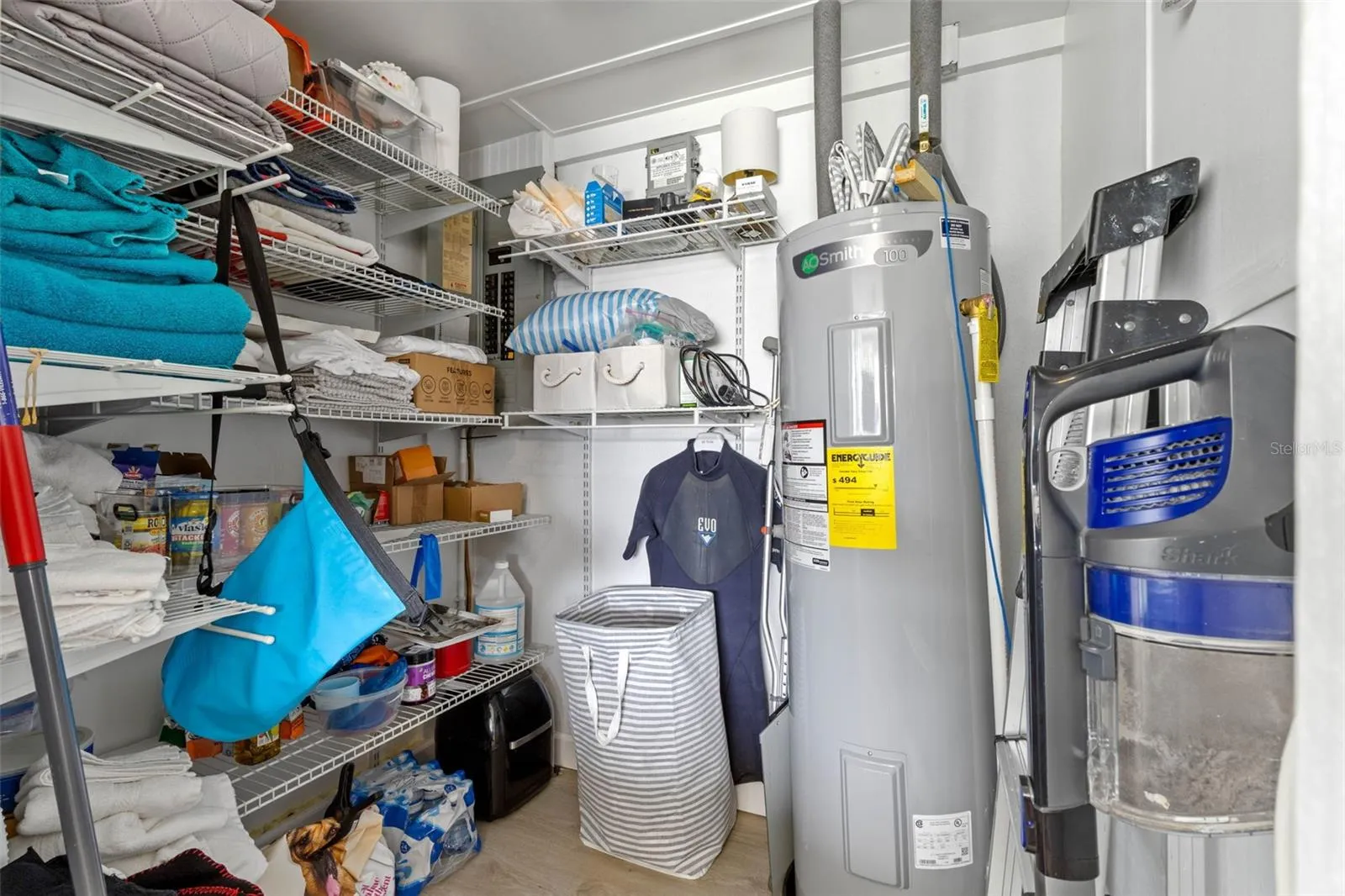 A dedicated utility and storage room keeps household essentials organized with extensive wire shelving and a water heater (2025) tucked neatly to one side.