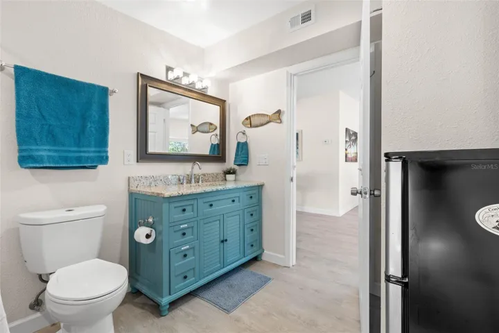 The updated second bath (2019) adds a splash of personality with a turquoise vanity, stone-look countertop, framed mirror, modern lighting, and plenty of built-in storage.