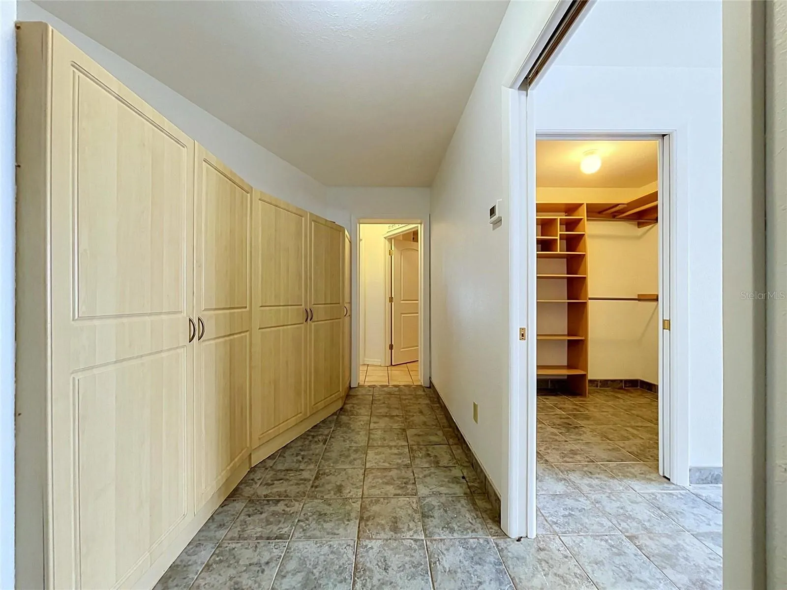 Hallway to garage and Bathroom 3 with cabinets
