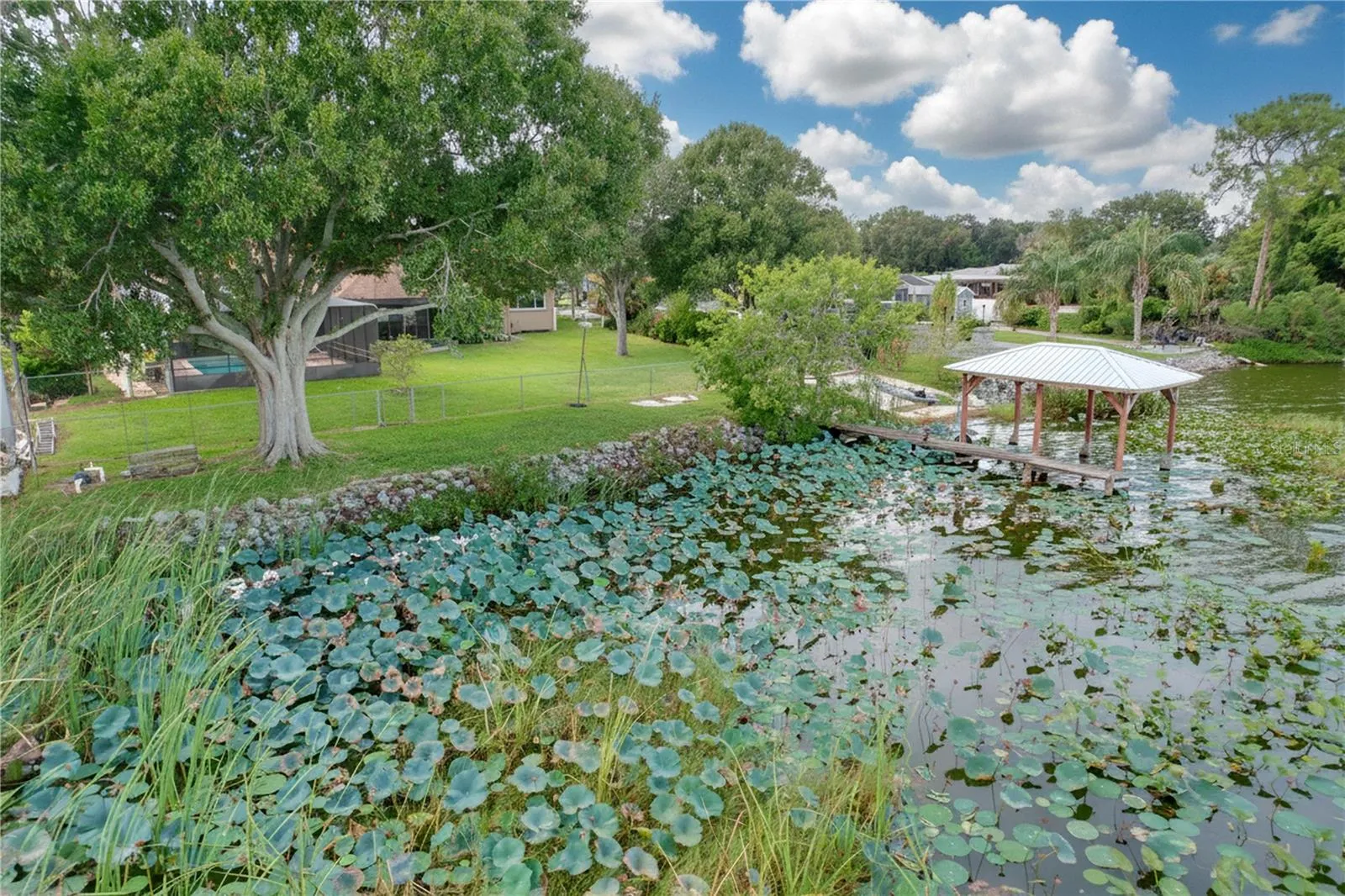 Aerial view from water of backyard, dock, and ramp