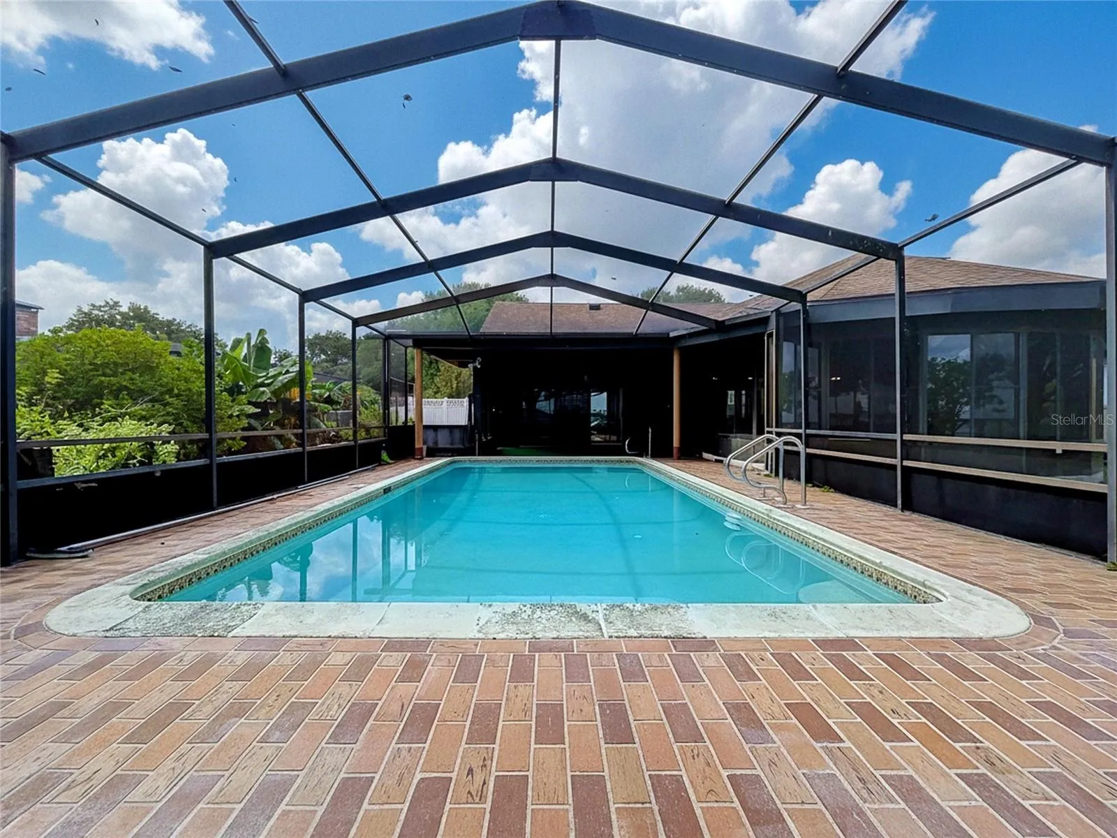 In-ground pool with screened enclosure