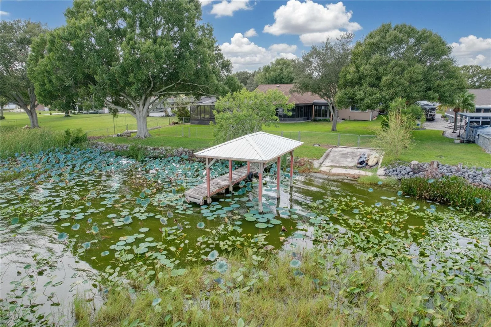 Aerial view from water of backyard, dock, and ramp