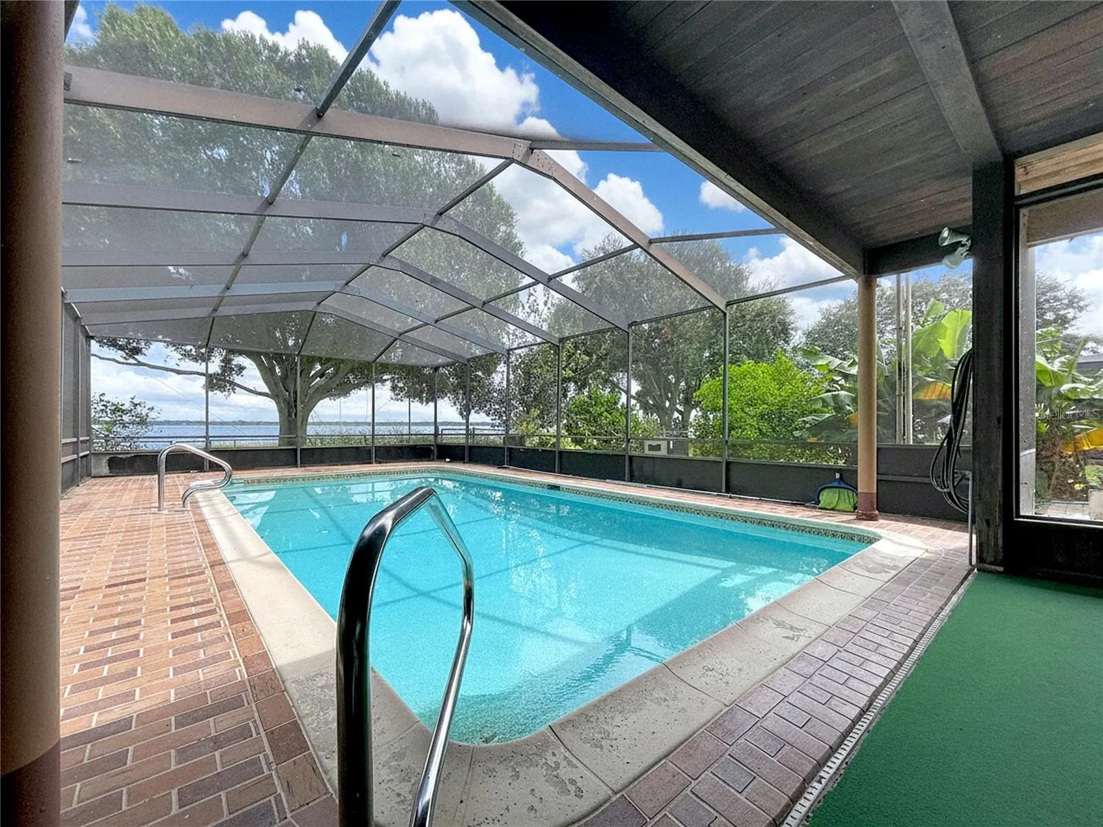 In-ground pool with screened enclosure