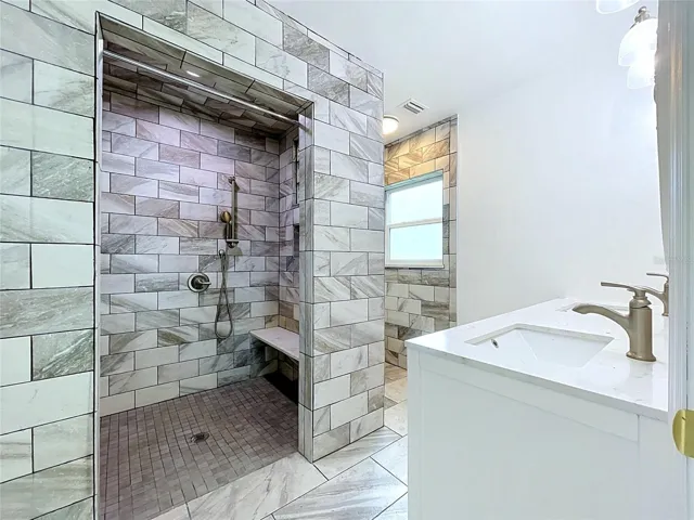Bathroom 1 with tiled shower and vanity