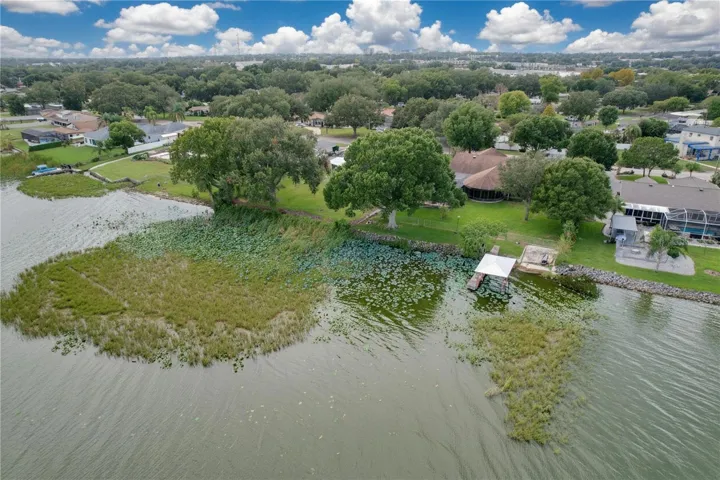 Aerial view from water of backyard, dock, and ramp