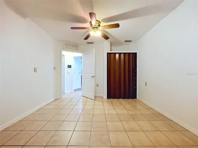 Bonus room with tile flooring and ceiling fan
