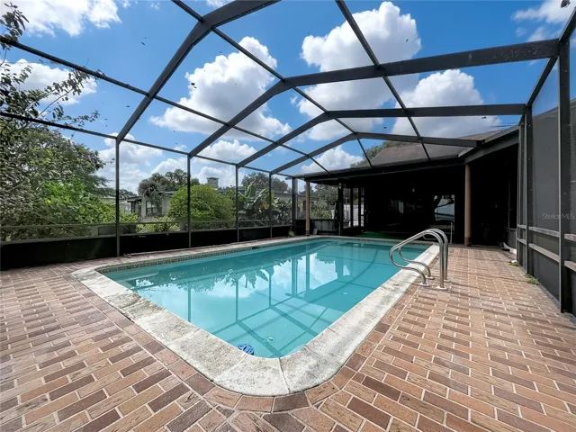 In-ground pool with screened enclosure