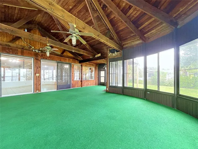 Lanai with large windows and vaulted wood ceiling
