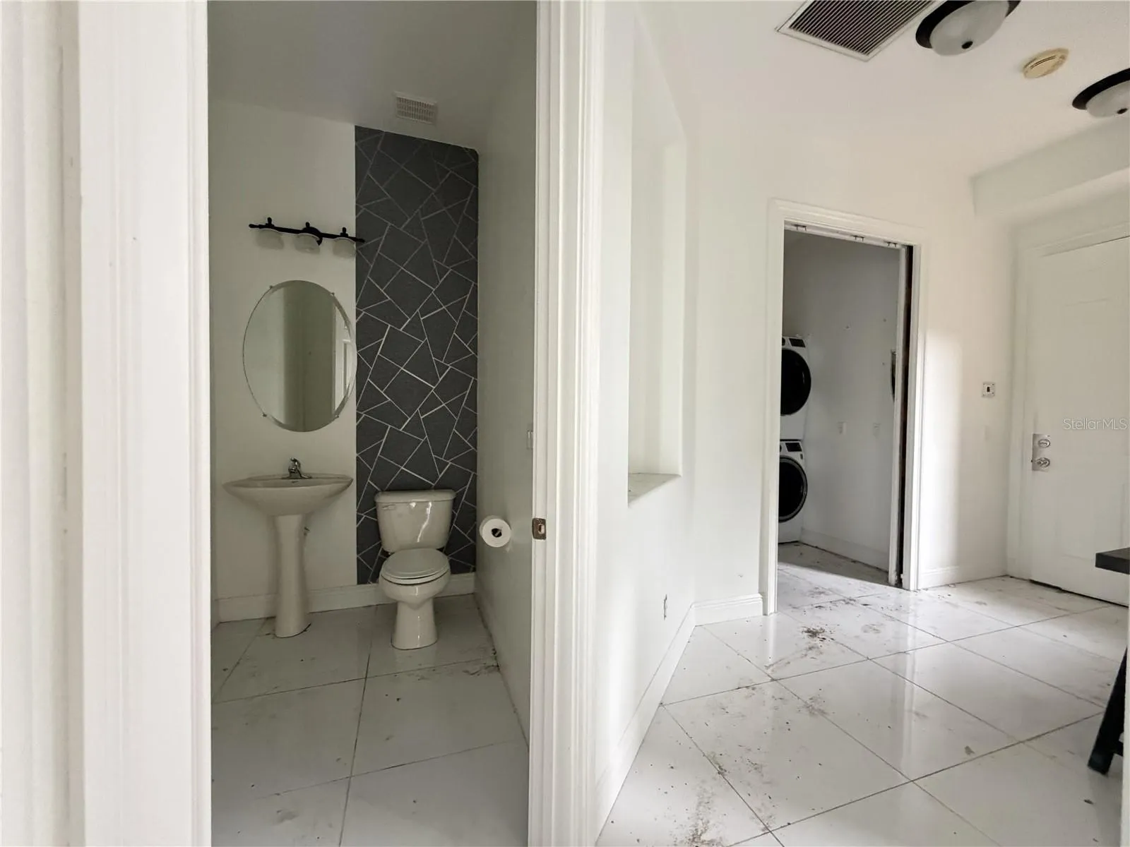 Half bathroom with pedestal sink and decorative accent wall.