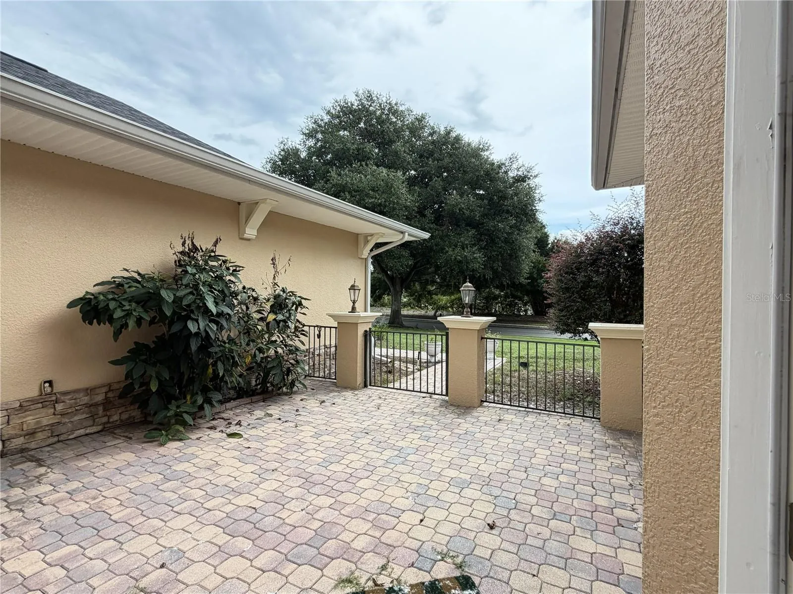 Paver entry courtyard with decorative metal fencing.