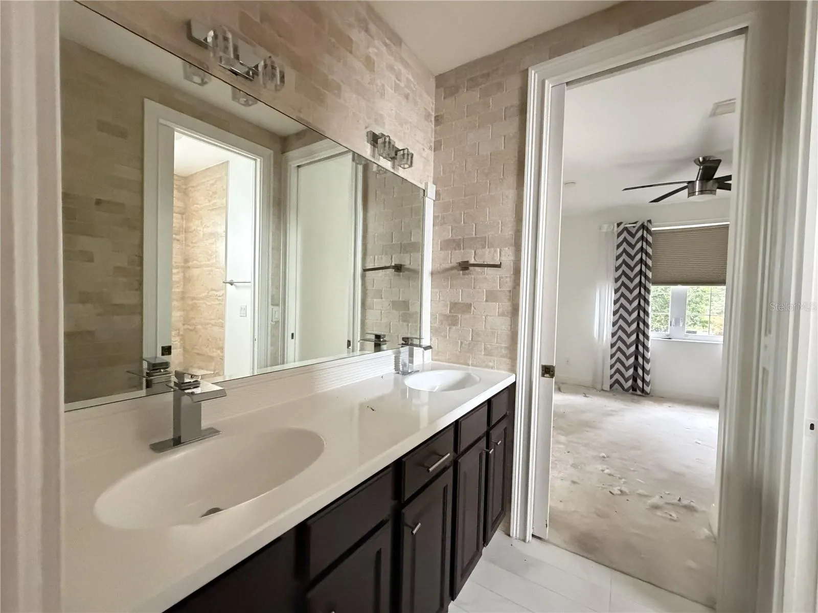Second full bathroom with dual sinks and extended vanity.
