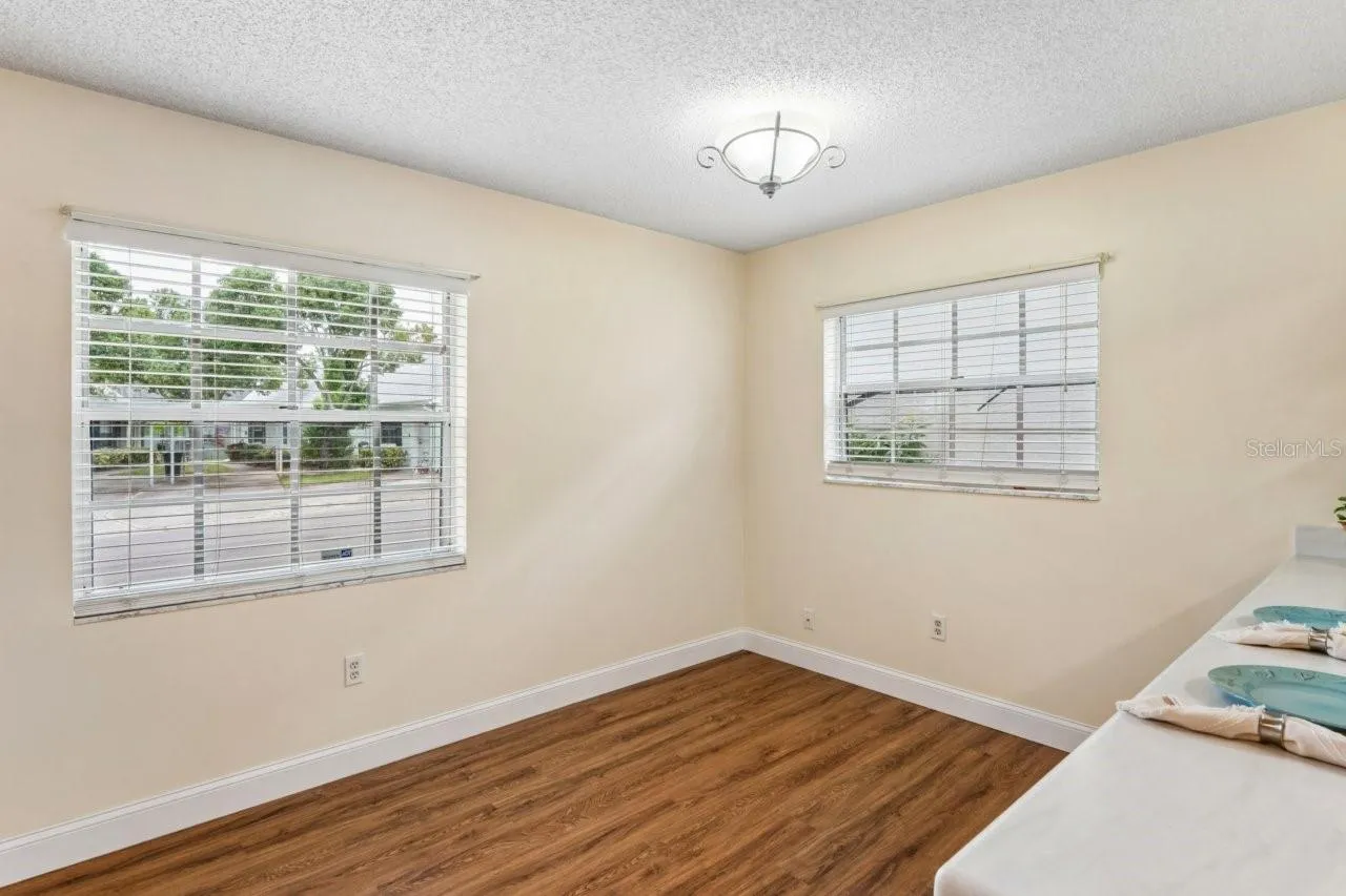 This area is the dining room with access to the breakfast bar and two windows. Newer flooring throughout.