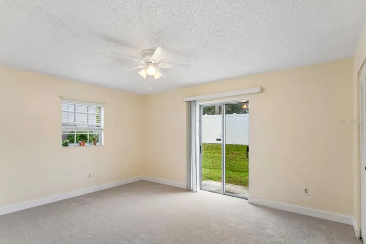 The bedroom has a slider, window, ceiling fan, access to the bathroom and walk in closet, and brand NEW carpeting.