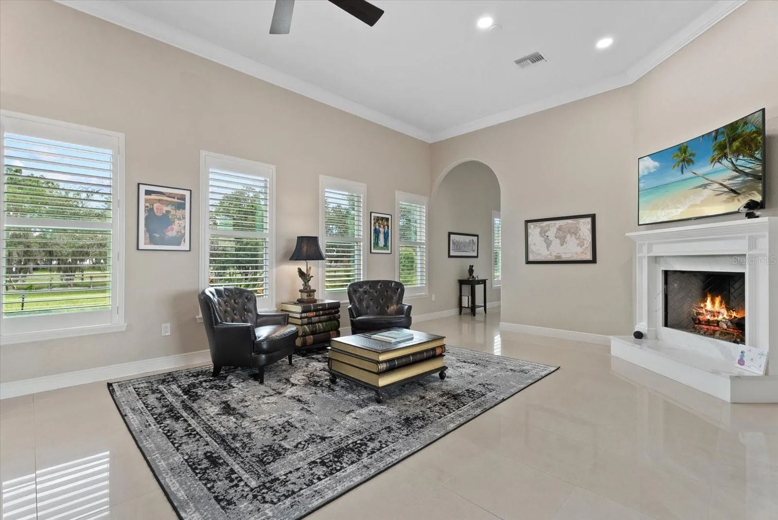 The family room is surrounded by windows with plantation shutters as well as sliders leading to the pool deck