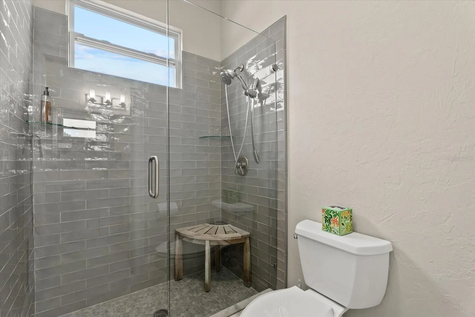 The toilet and shower area are closed off from the shared sink area of the Jack and Jill bathroom upstairs