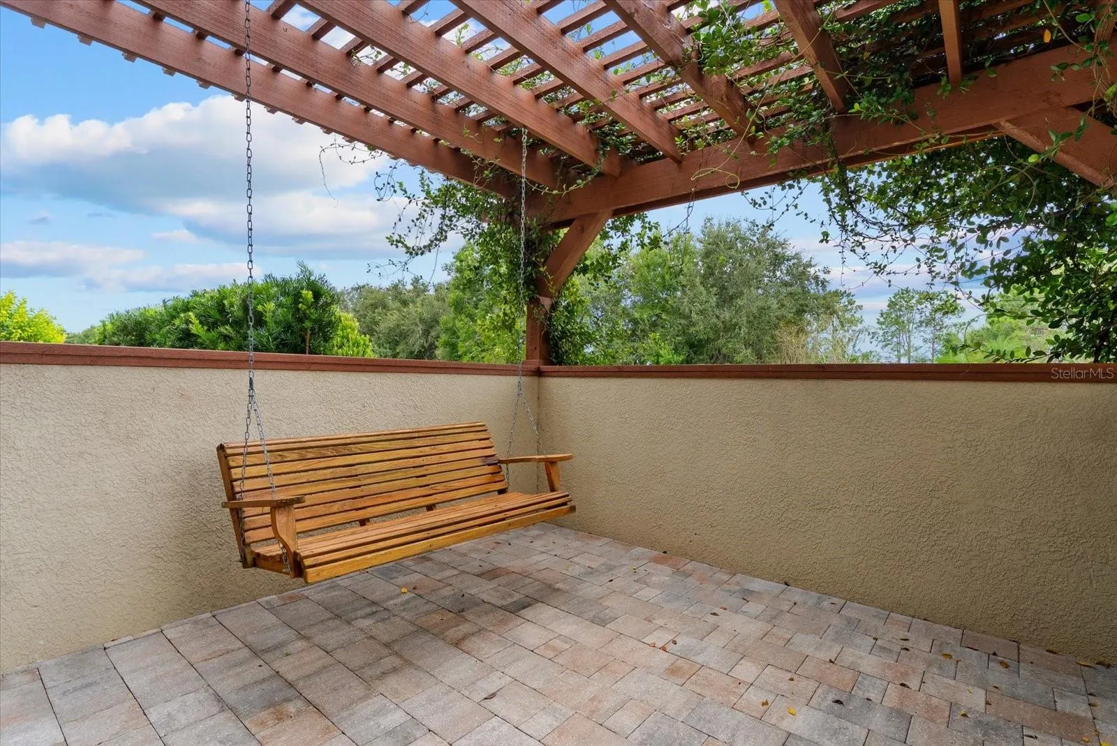 A porch swing and vine covered trellis adorn the side patio off the dining room