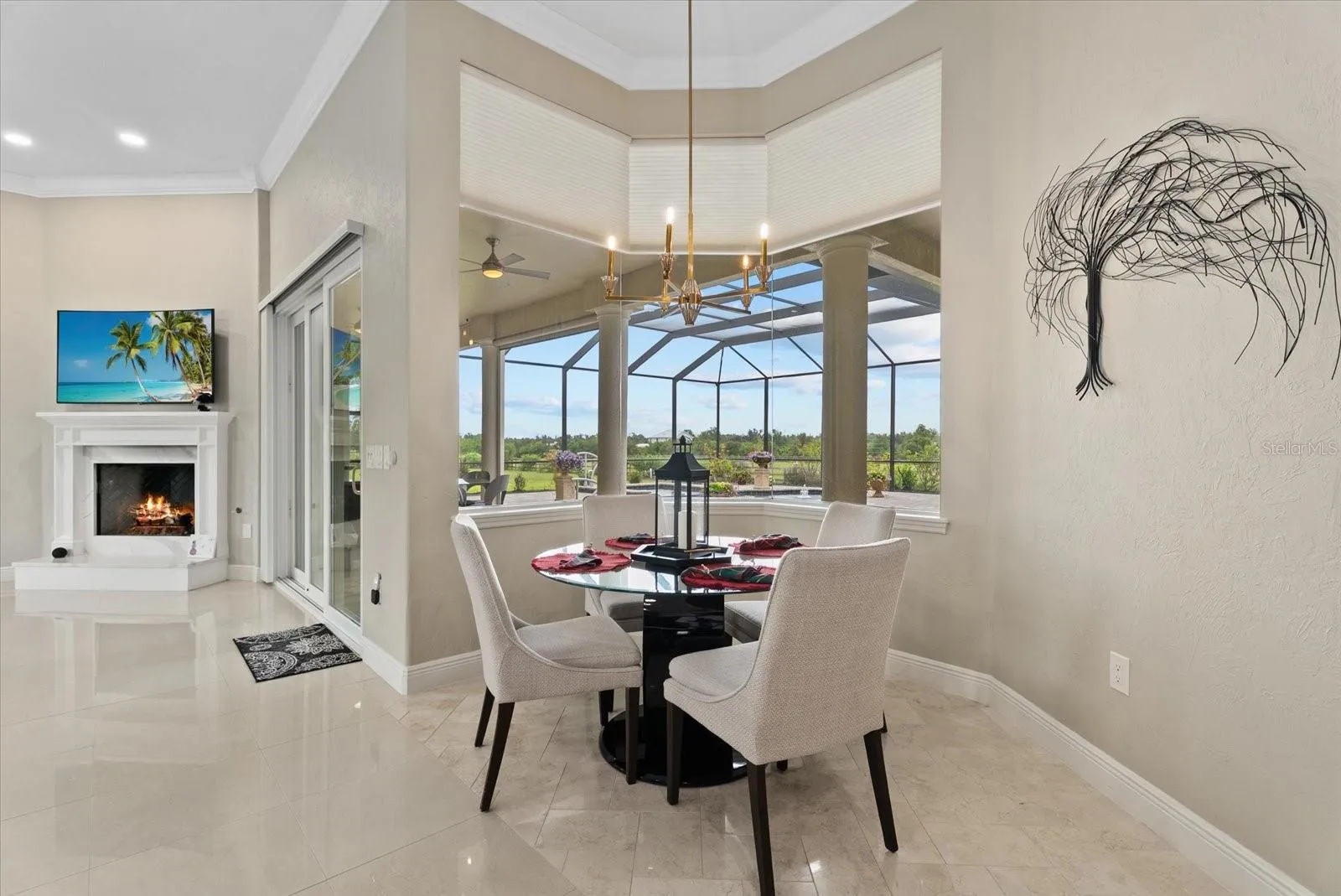 The breakfast nook is surrounded by aquarium glass windows looking out on the pool deck and pastures