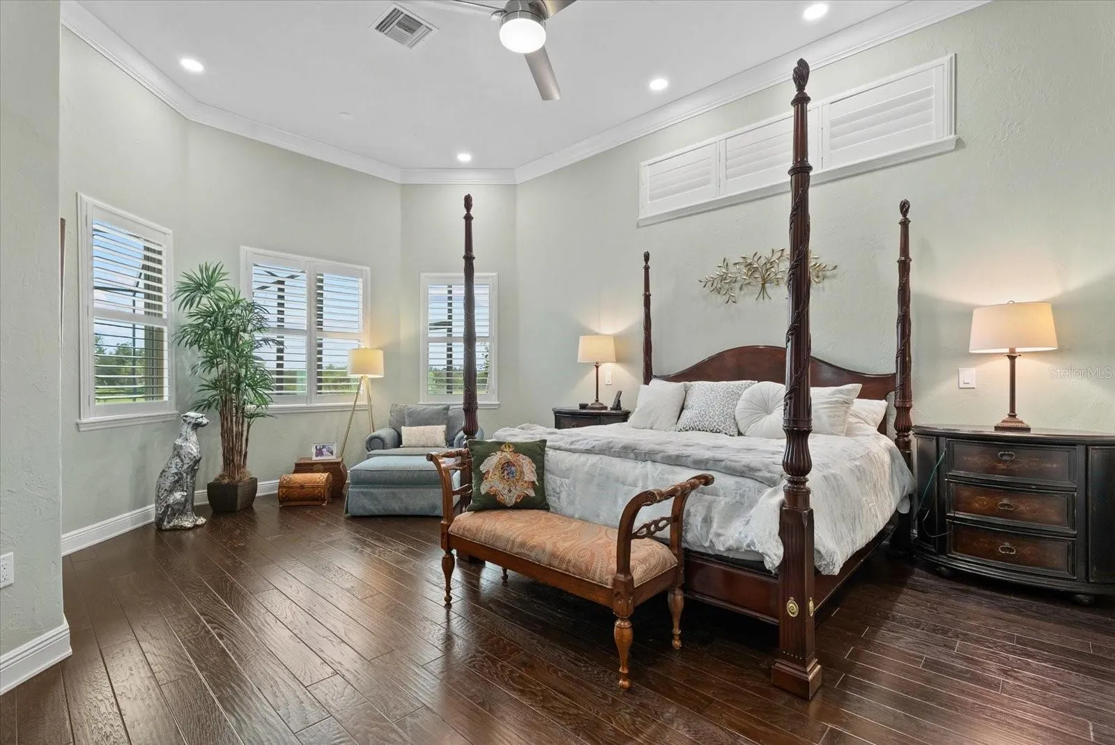 Also on the first floor is a spacious primary suite with high ceilings, wood floors, clerestory windows over the bed, crown molding and an entry door to an outside lounge space