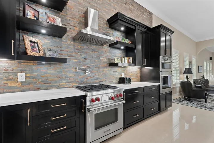 The home offers a gas range/cooktop, built-in oven and microwave with marble countertops