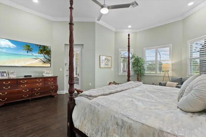 The primary suite is adorned with plantation shutters and recessed lighting