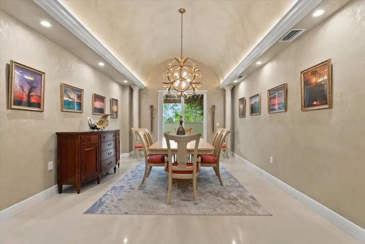 The dining room features a coved ceiling, fine millwork, and french doors leading to a side patio