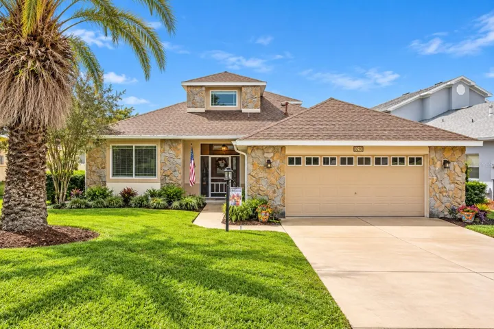 This well-built block home features attractive stone accents, tropical landscaping, and a welcoming entrance.
