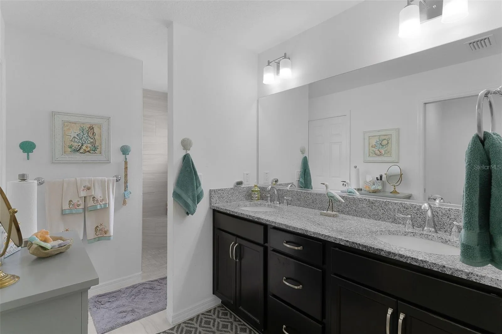 Dual sinks with granite countertops &amp; Roman shower.