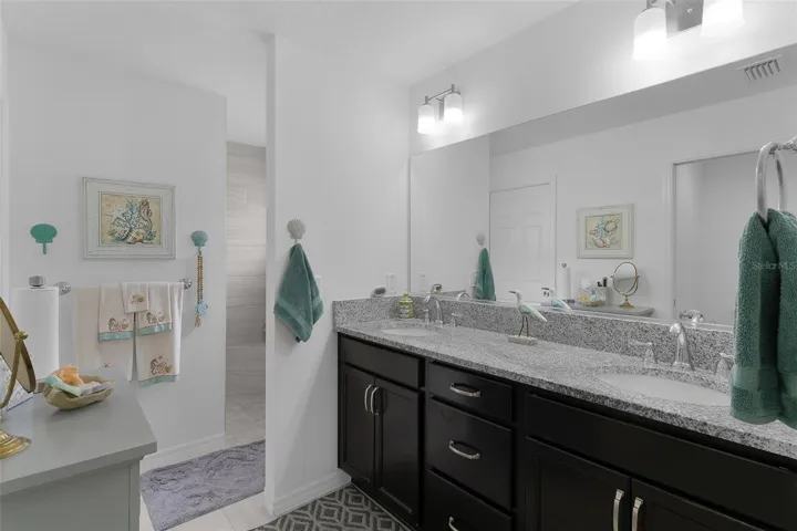 Dual sinks with granite countertops &amp; Roman shower.