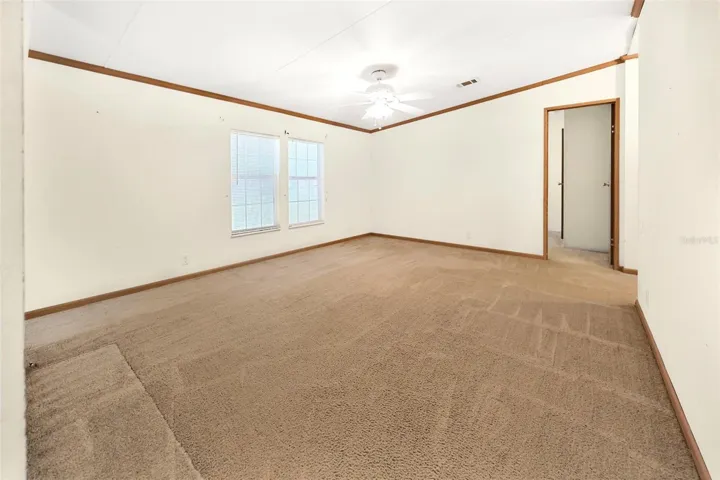 Sitting area next to living room leading to secondary bedrooms