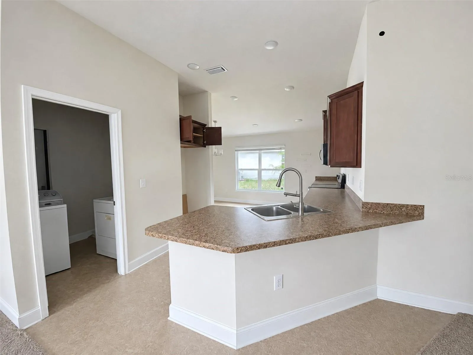 Kitchen, Peninsula with Counter Seating, with Eat in Dining Area. View of Laundry Room.
