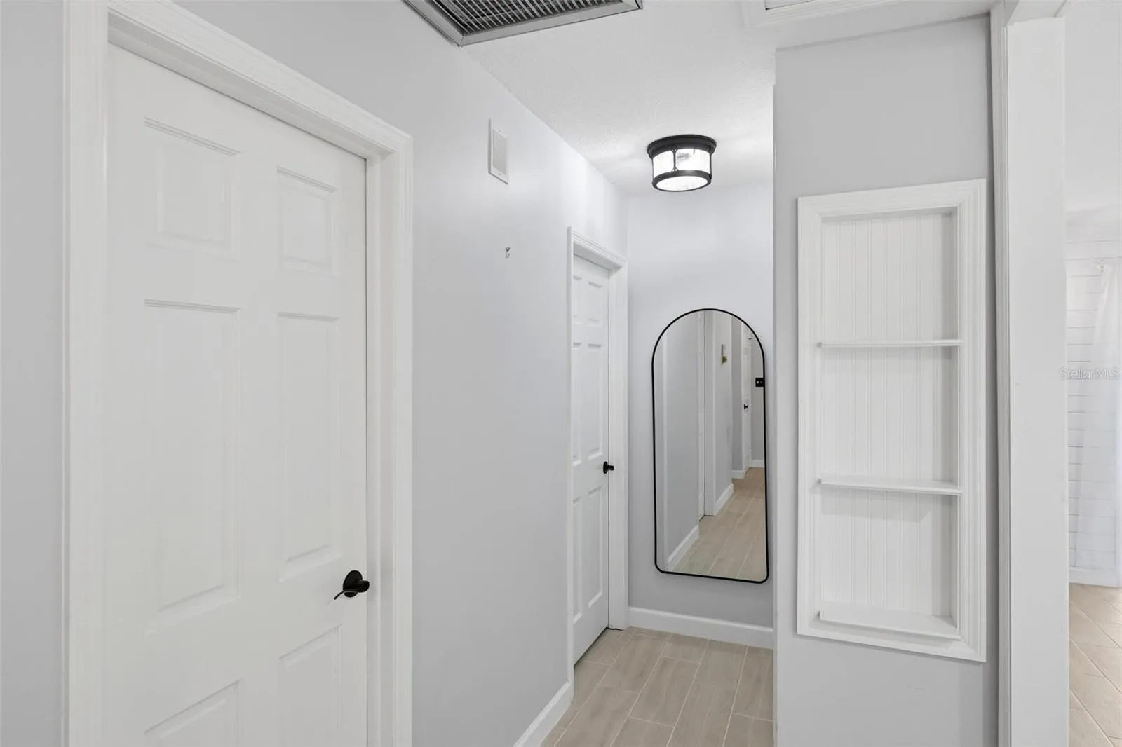 the hallway to the bedroom area.  Full length mirror for that double check before you leave the home.  A built in shelving unit for displaying favorite items.