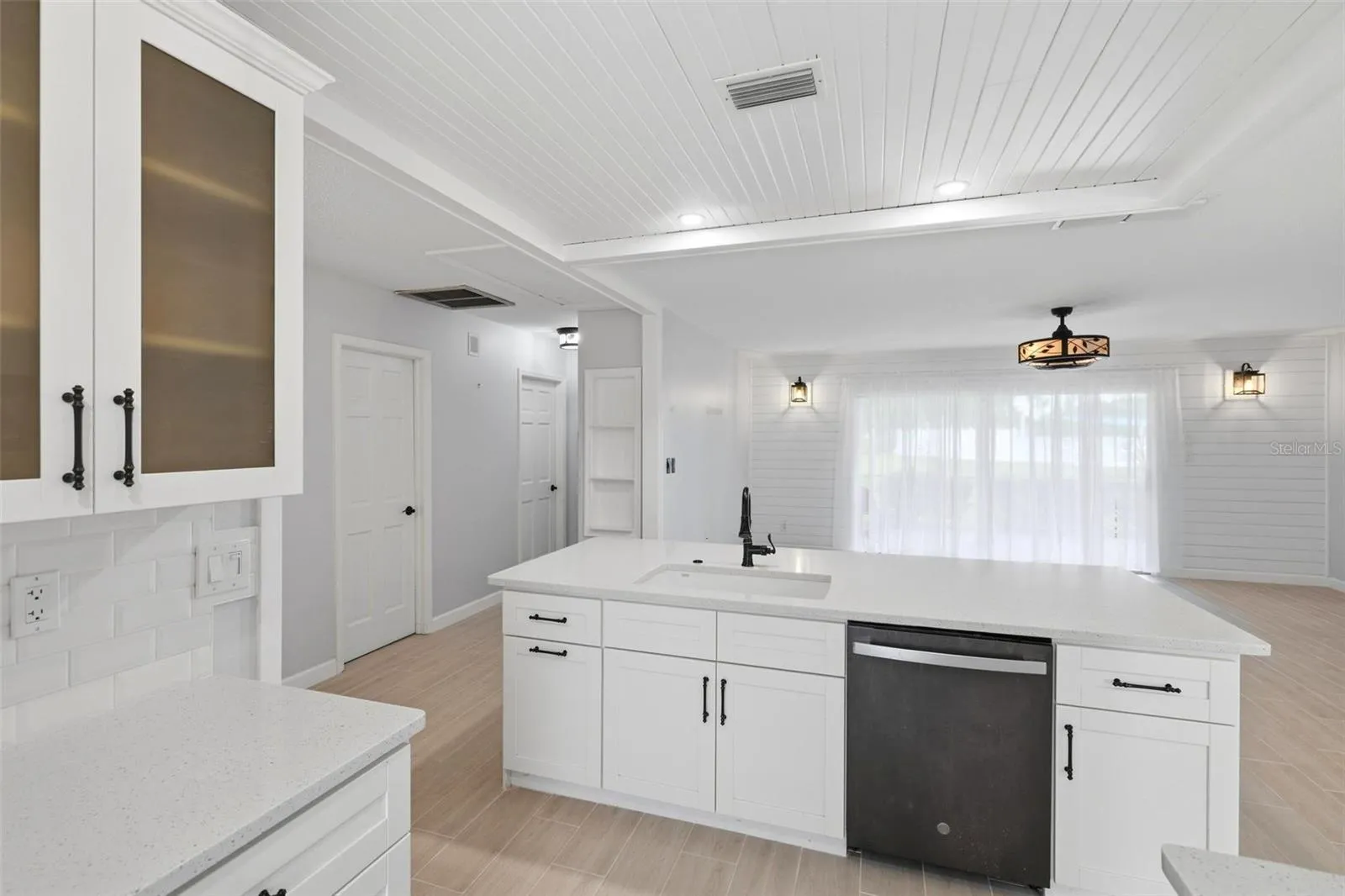 The opposite side of breakfast bar shows the sink, dishwasher and extra storage cabinetry.