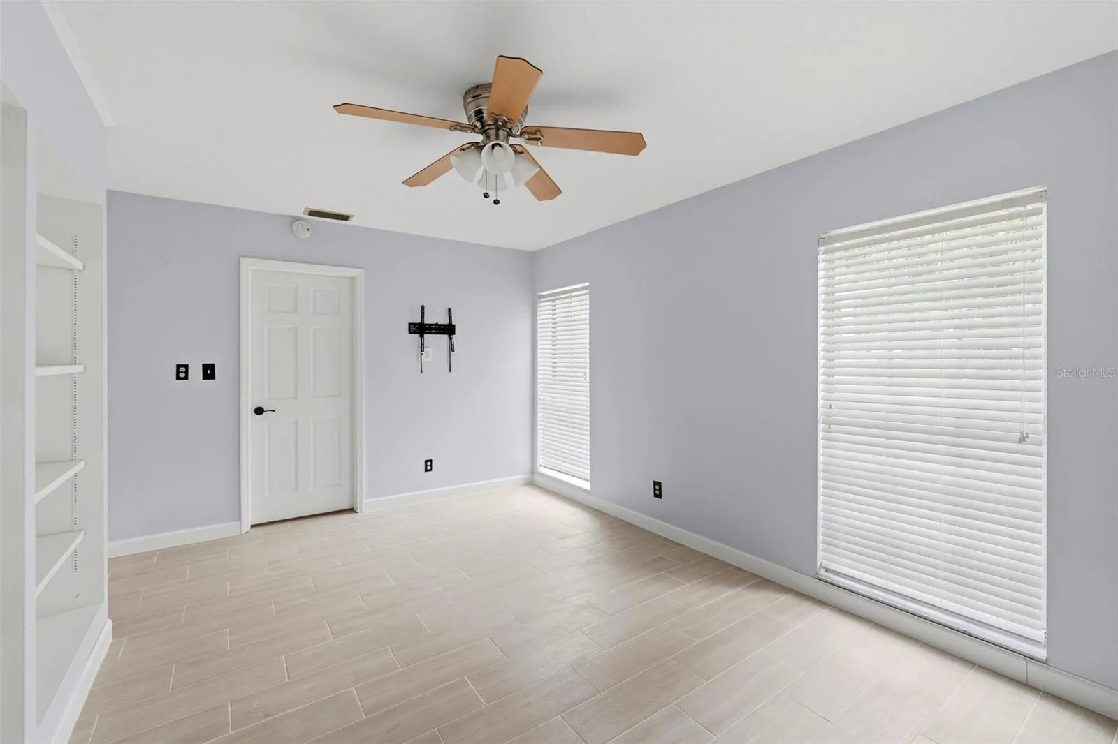 2nd bedroom bright and cheerful with two long, large windows full of natural light.  Built shelving unit.