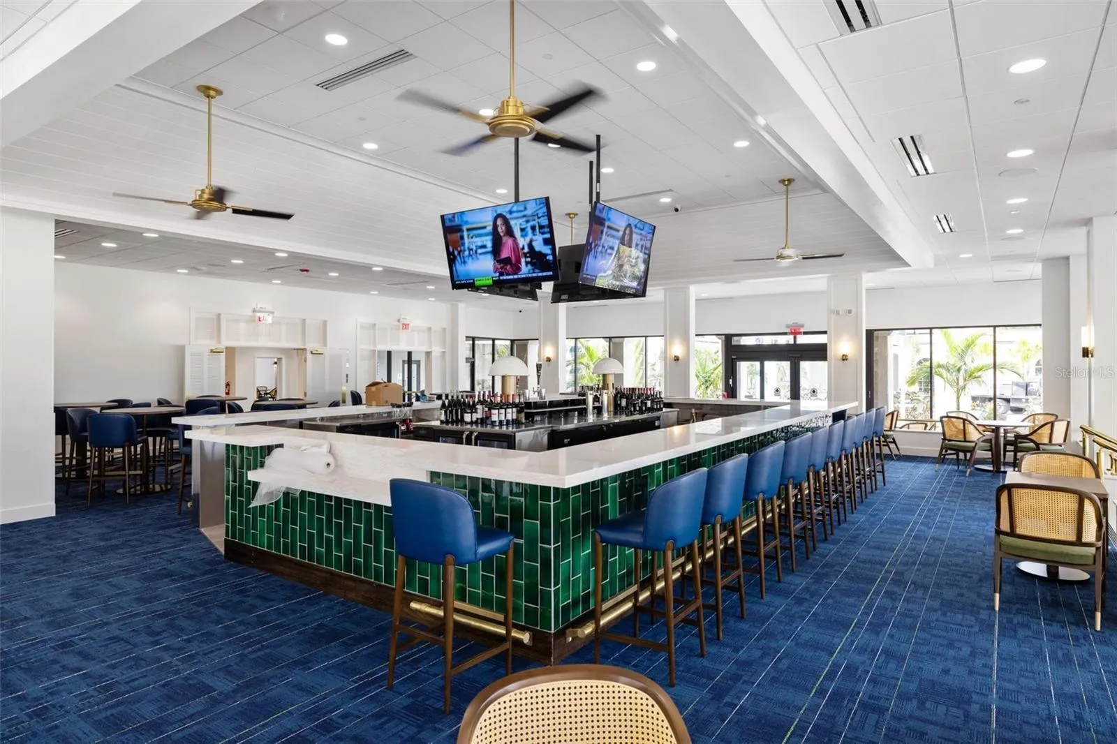 Interior of clubhouse with large bar area.  Lots of windows overlooking golf course