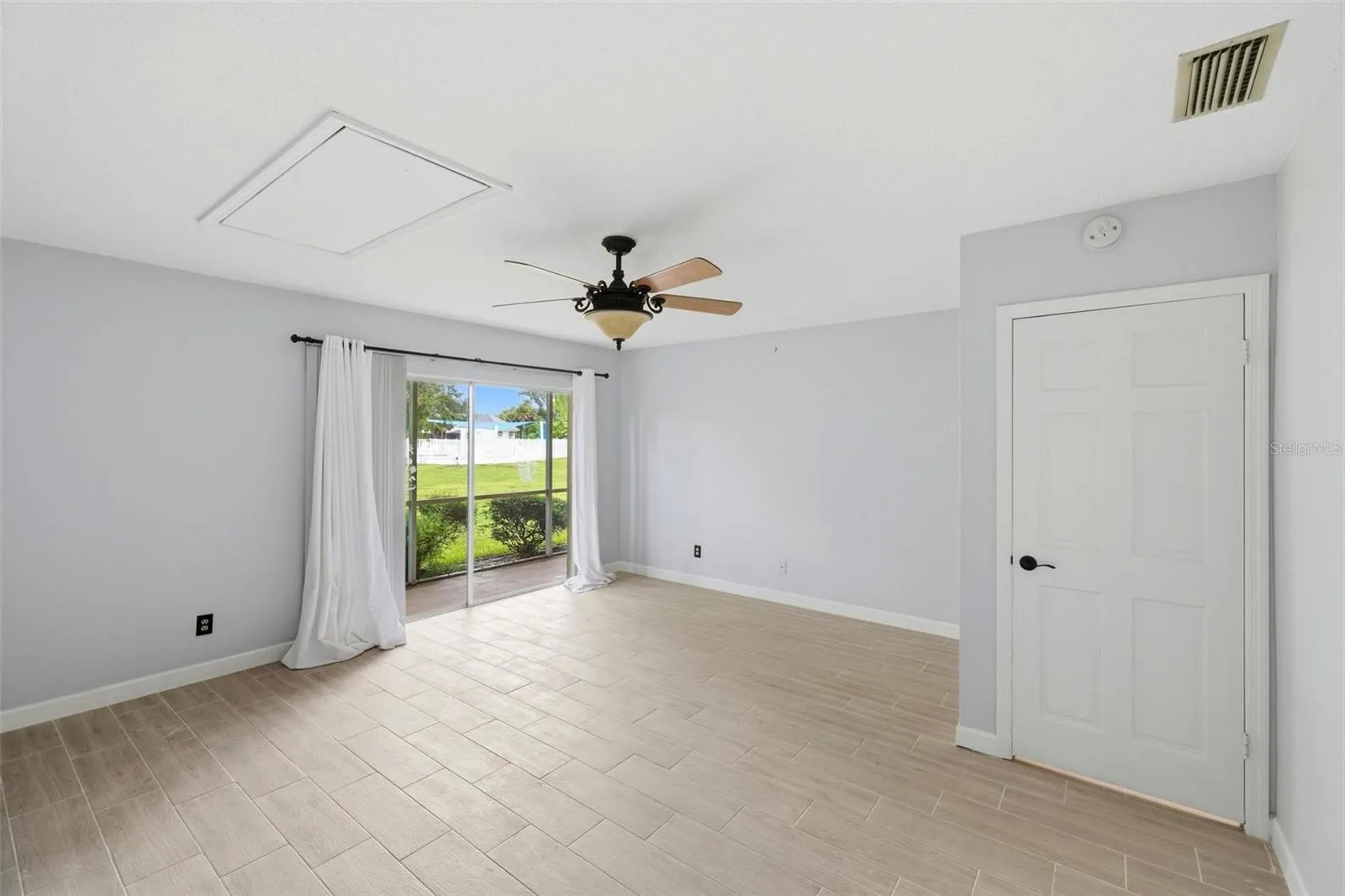 Large primary bedroom with patio doors onto lanai.