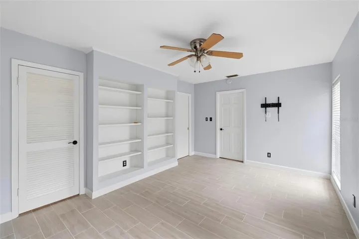 Full view of the built in shelves in the 2nd bedroom.  Door to closet and door to laundry room.